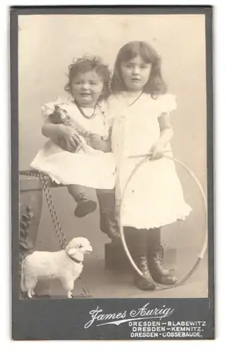Fotografie James Aurig, Dresden, zwei niedliche kleine Mädchen mit Stoff Schaf auf Rädern