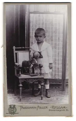 Fotografie Atelier National, Potsdam, junger Knabe Maschke mit Spielzeug Kuh und Ball in der Hand