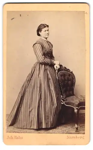 Fotografie Joh. Hahn, Nürnberg, junge Dame im gestreiften Kleid am Stuhl stehend