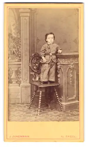 Fotografie J. Jungmann, Klein Basel, junger schweizer Knabe im Anzug posiert auf einem Stuhl stehend