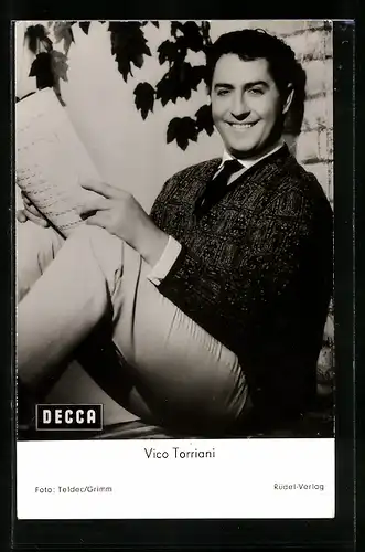 AK Schauspieler Vico Torriani sitzt lächelnd an einer Wand