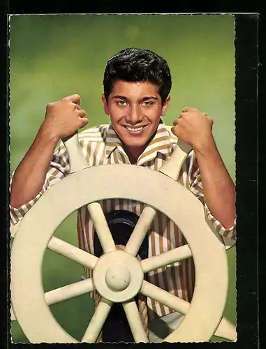 AK Musiker Paul Anka lächelnd an einem Schiffsrad