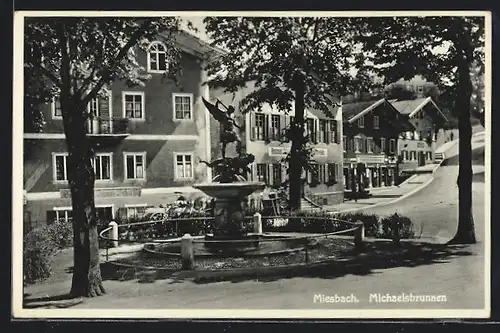 AK Miesbach, Strassenpartie mit Geschäften und Michaelsbrunnen