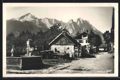 AK Garmisch, Frühlingsstrasse mit Brunnen gegen die Zugspitze