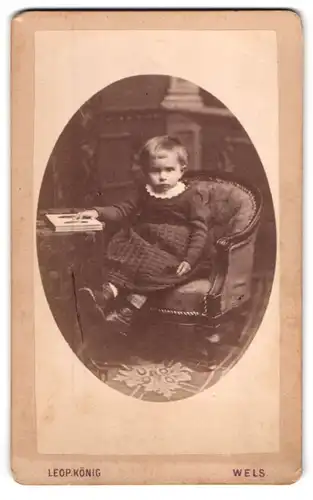 Fotografie Leop. König, Wels, Linzergasse, Kleines Kind im Kleid mit einem Buch