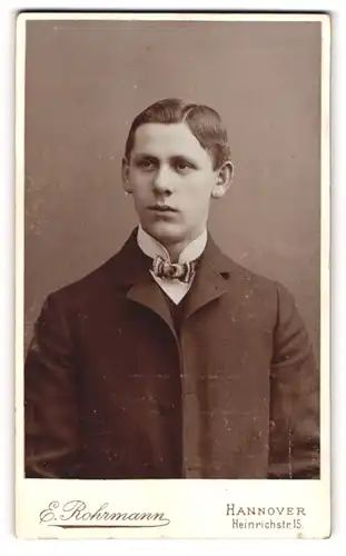 Fotografie E. Rohrmann, Hannover, Heinrichstr. 15, Junger Mann im Anzug mit gemusteter Fliege und grossen Ohren