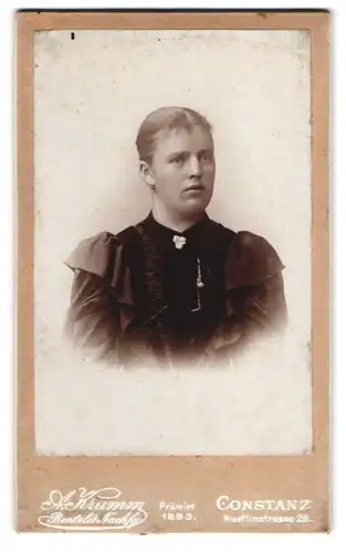 Fotografie A. Krumm, Constanz, Huetlinstrasse 29, Junge Dame mit krummer Nase und rundem Gesicht in schwarzem Kleid