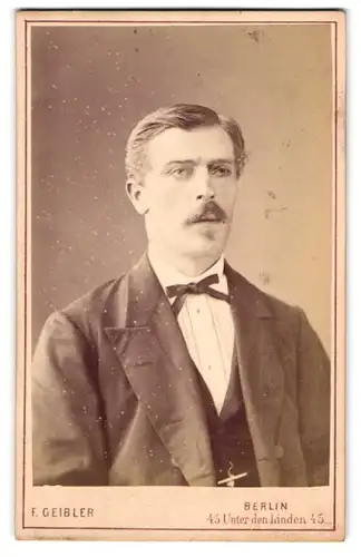 Fotografie F. Geibler, Berlin, Unter den Linden 45, Mann im Anzug mit Moustache und Schleife