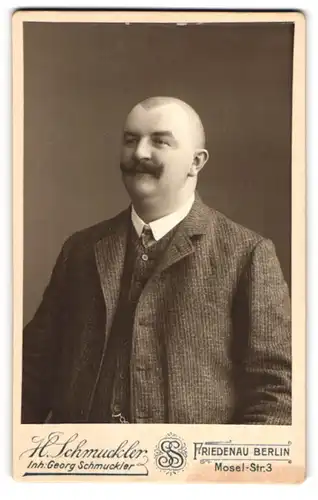 Fotografie H. Schmuckler, Berlin-Friedenau, Mosel-Str. 3, Portrait Mann mit rasiertem Kopf und Schnauzer
