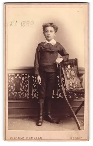 Fotografie Wilhelm Kersten, Berlin, Krausen- Str. 40, junger Knabe angelehnt an Stuhl, 1889