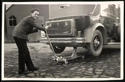 Fotografie Auto Cabrio, junge Frau hebt PKW mit Rangierwagenheber an