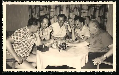 Fotografie Schach - Chess, Männerrunde sitzt gesellig um Schachbrett herum