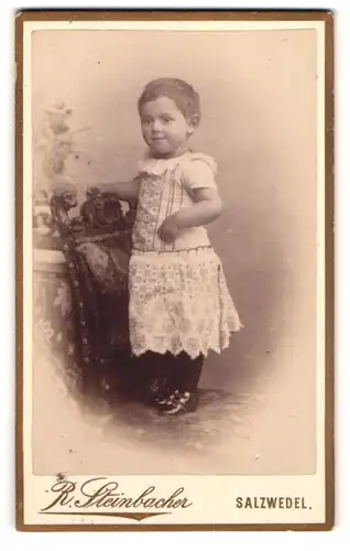 Fotografie R. Steinbacher, Salzwedel, Neuperverstr. 38, Portrait Kleinkind auf Stuhl stehend