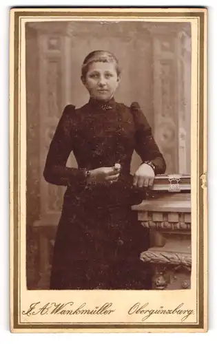 Fotografie J. A. Wankmüller, Obergünzburg, Portrait junge Frau an Tisch angelehnt