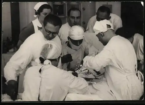 Fotografie Operationssaal, Chirurg nebst OP-Schwester und Assistenten während einer Operation