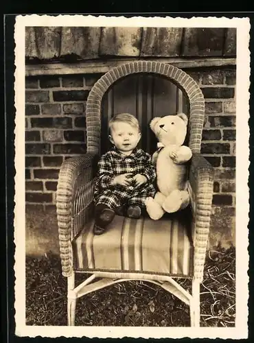 Fotografie Lange, Braunschweig, Knabe mit teddybär, Teddy, Teddybear auf Korbsessel sitzend