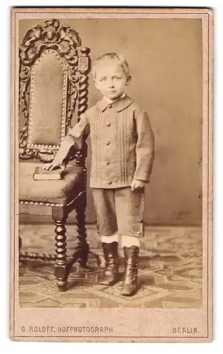 Fotografie O. Roloff, Berlin, Taubenstr. 20, Junge mit Lederstiefeln und Buch
