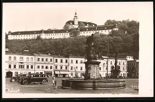 Fotografie unbekannter Fotograf, Ansicht Fulnek, Ortsansicht mit Marktplatz, Brunnen, Schloss & Ladengeschäften