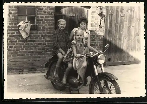 Fotografie Motorrad, Mädchen mit Zöpfen auf Krad sitzend