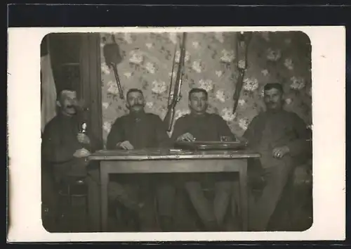 Foto-AK Vier Soldaten mit Zither an einem Tisch sitzend, Gewehr und Bajonett hängen an der Wand