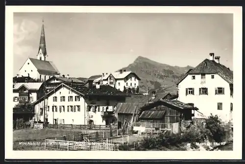 AK Kirchbichl, Ortsansicht mit Kirche und Berggipfel