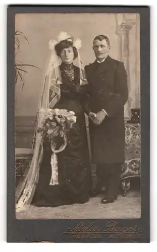 Fotografie Atelier Berger, Kempten, Hochzeitspaar im schwarzen Brautkleid und Anzug mit Mantel