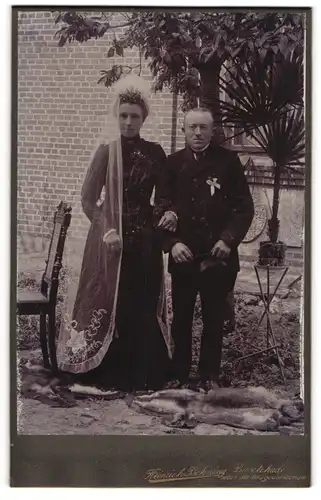 Fotografie Heinrich Behning, Buxtehude, Hochzeitspaar im schwarzen Brautkleid und im Anzug mit Zylinder