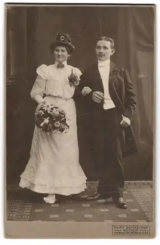 Fotografie Kurt Schneider, Bochum, junges Hochzeitspaar im Brautkleid und im Anzug mit Brautstrauss