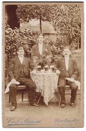 Fotografie Carl Marisal, Berlin, Köpenicker Str. 126, drei Männer posieren im Garten mit Schwarzbier auf dem Tisch