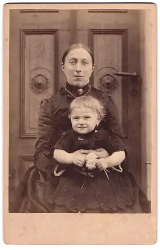 Fotografie unbekannter Fotograf und Ort, Portrait junge Mutter mit ihrer Tochter auf dem Schoss