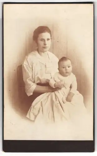 Fotografie unbekannter Fotograf und Ort, junge Mutter mit ihrem Sohn Hans auf dem Schoss, 1920