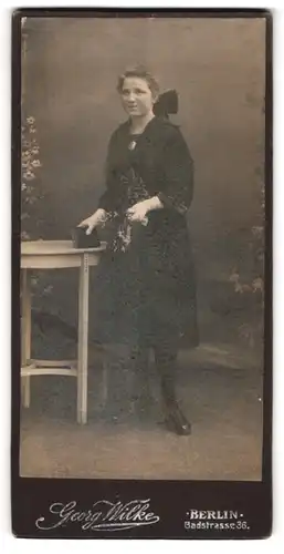 Fotografie George Wilke, Berlin, Badstrasse 36, Junge Dame im schwarzen Kleid mit Blumenmuster und goldener Kette