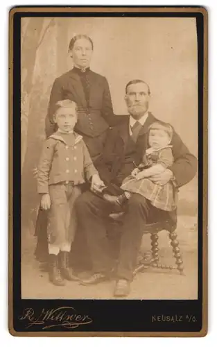Fotografie R. Wittwer, Neusalz a. O., Gutbürgerliche Familie in eleganter Kleidung mit Kleinkind auf dem Schoss