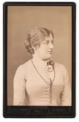 Fotografie C. Pietzner, Tetschen a. E., Bahnhofstrasse, Junge Dame im weissen Kleid mit langer Perlenkette und Blumen