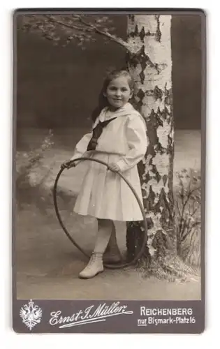 Fotografie Ernst J. Müller, Reichenberg / Liberec, junges Mädchen Hilde Jantsch im weissen Kleid lehnt an Birke, 1898
