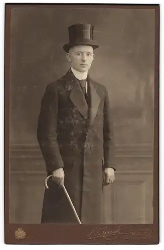 Fotografie H. Noack, Berlin, junger Mann im Anzug mit Mantel, Zylinder und Flanierstock