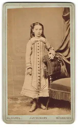 Fotografie J. Jungmann, Kl. Basel, Hammerstr. 13, niedliches Mädchen im langen Stoffkleid mit Locken