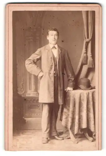 Fotografie Wilhelm Kersten, Berlin, Portrait stattlicher Herr mit Melonenhut im Mantel