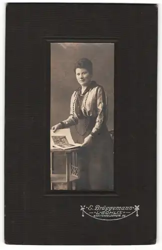 Fotografie E. Brüggemann, L.-Gohlis, Portrait bürgerliche Dame mit Buch an Tisch gelehnt