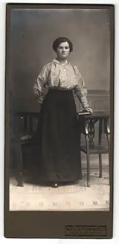 Fotografie Alex Lauterwasser Jr., Ueberlingen a / B., Portrait junge Dame in karierter Bluse mit Buch an Tisch gelehnt