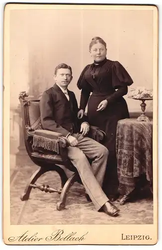 Fotografie Carl Bellach, Leipzig, Portrait bürgerliches Paar in modischer Kleidung am Tisch
