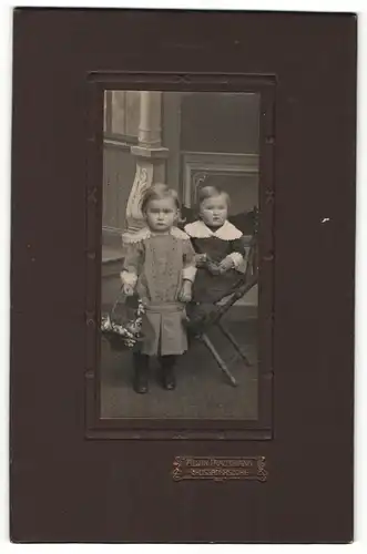 Fotografie Alwin Trautmann, Grossröhrsdorf, Portrait zwei kleine Mädchen in hübschen Kleidern mit Blumenkorb