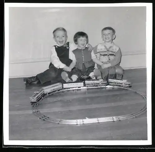 Fotografie lachende Kinder spielen mit Modell-Eisenbahn