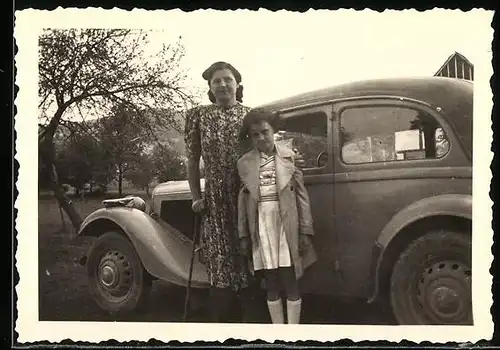 Fotografie Auto, Mutter & Tochter neben PKW stehend