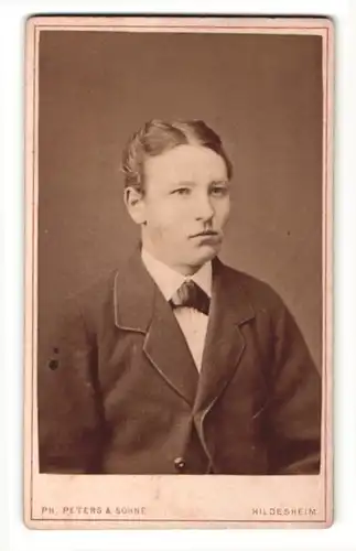 Fotografie Ph. Peters & Söhne, Hildesheim, Portrait dunkelhaariger Mann mit Fliege im Anzug