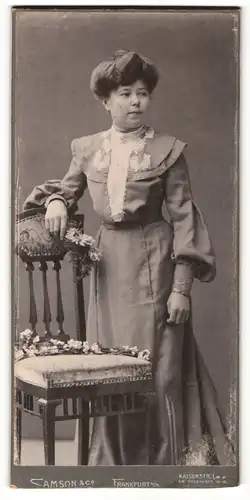 Fotografie Samson & Co, Frankfurt a / M., Portrait bürgerliche Dame mit Blumen an Stuhl gelehnt