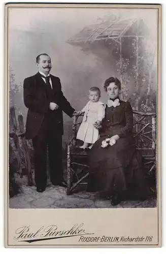 Fotografie Paul Purschke, Berlin-Rixdorf, Portrait elegant gekleidetes Paar mit kleiner Tochter