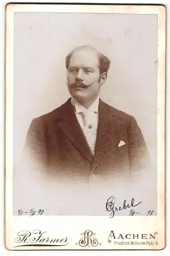 Fotografie R. Farmer, Aachen, Mann mit hochgedrehtem Schnauzbart und weisser gestreifter Krawatte