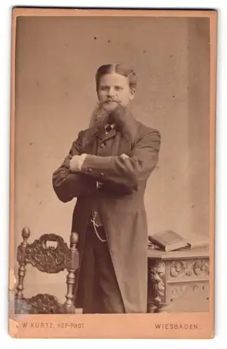 Fotografie L. W. Kurtz, Wiesbaden, Portrait modisch gekleideter Herr mit Bart und verschränkten Armen