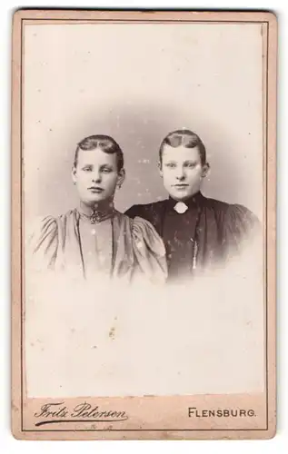 Fotografie Fritz Petersen, Flensburg, Portrait zwei junge Damen in eleganten Kleidern mit Puffärmeln